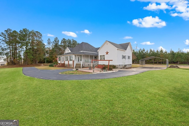 back of house with a porch, a carport, and a lawn