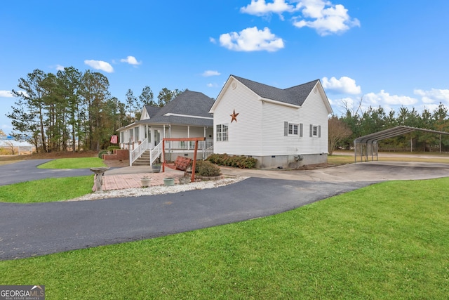 view of front of house featuring a front yard, a carport, and covered porch