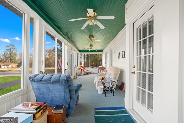 sunroom featuring plenty of natural light, wooden ceiling, and ceiling fan