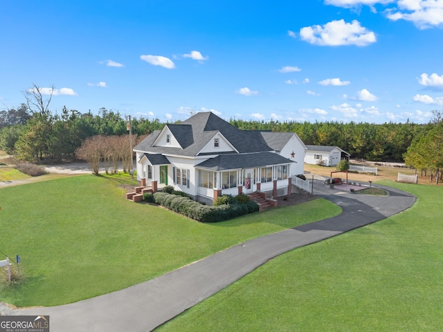 view of front of house with a sunroom and a front lawn