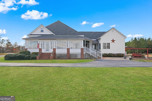 view of front of house featuring a front lawn and a sunroom