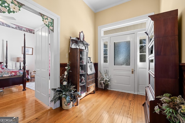 entrance foyer featuring crown molding and light hardwood / wood-style flooring