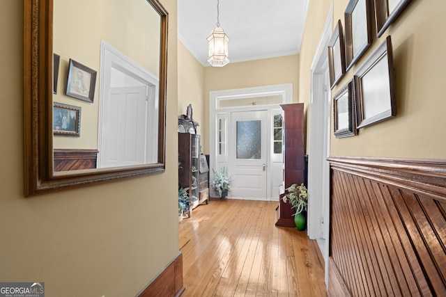 hallway with crown molding and light wood-type flooring