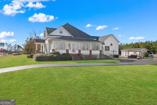 view of front of home featuring a front lawn and a sunroom