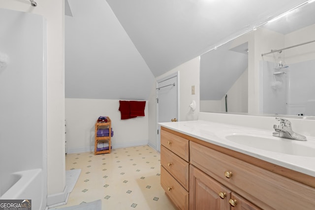 bathroom with lofted ceiling, vanity, and walk in shower