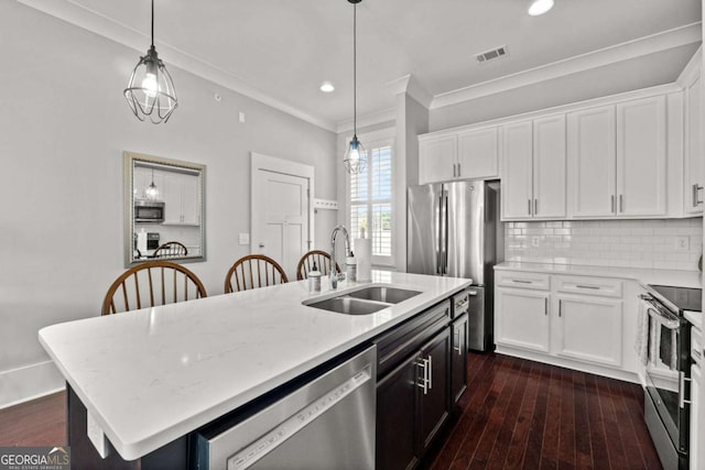 kitchen with stainless steel appliances, sink, a center island with sink, and white cabinets