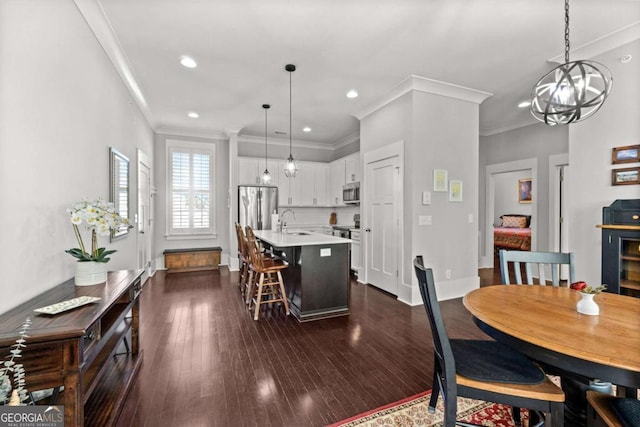 dining room featuring an inviting chandelier, ornamental molding, dark hardwood / wood-style floors, and sink