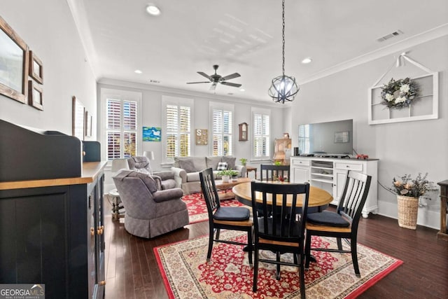 dining area featuring ornamental molding, dark hardwood / wood-style flooring, and ceiling fan with notable chandelier