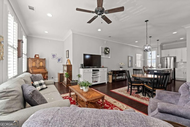 living room featuring dark hardwood / wood-style flooring, ornamental molding, and ceiling fan