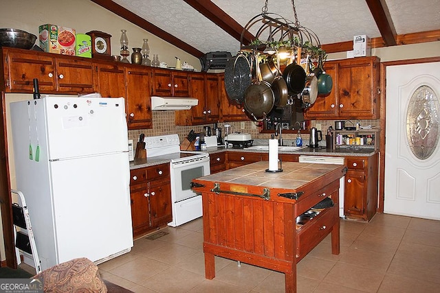 kitchen with lofted ceiling with beams, a center island, tile counters, white appliances, and a textured ceiling