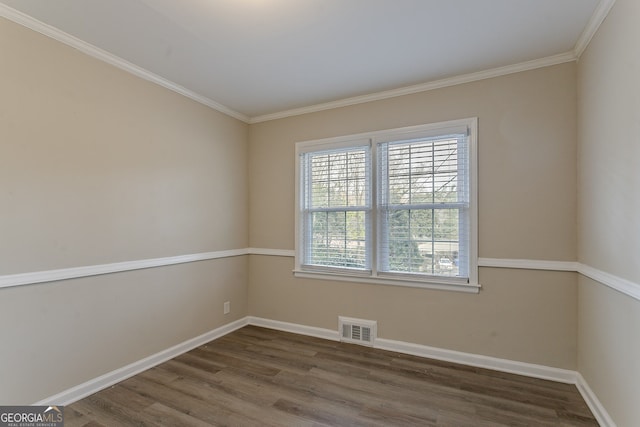 spare room with ornamental molding and dark hardwood / wood-style flooring