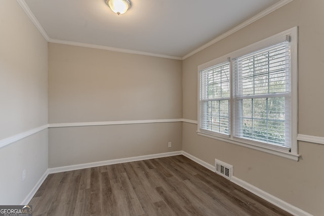 spare room featuring dark hardwood / wood-style flooring and ornamental molding