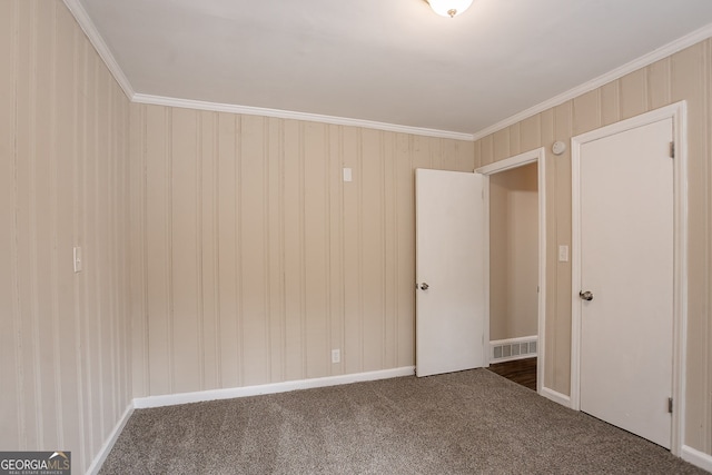 empty room with dark colored carpet and crown molding