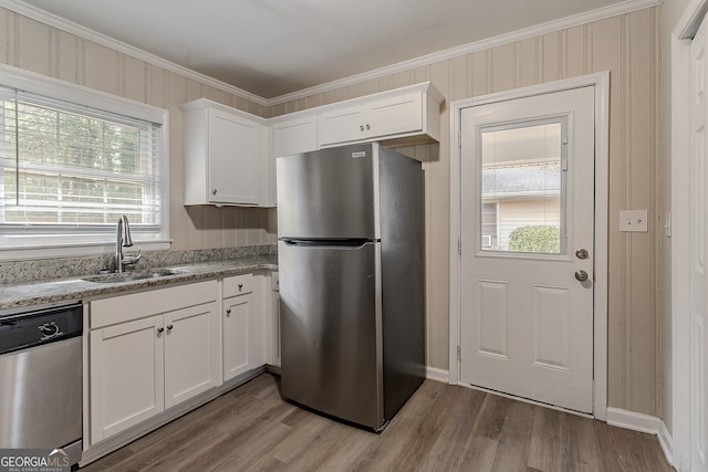 kitchen featuring appliances with stainless steel finishes, sink, white cabinets, and light stone counters