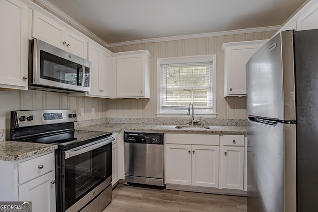 kitchen featuring white cabinetry, sink, stainless steel appliances, crown molding, and light stone countertops