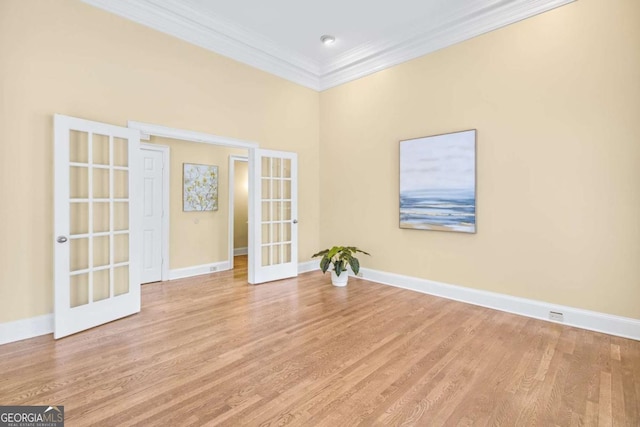 spare room featuring crown molding, light hardwood / wood-style floors, and french doors