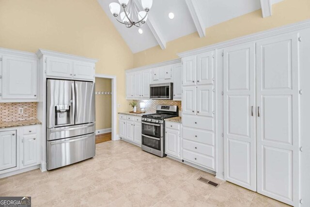 kitchen with hanging light fixtures, stainless steel appliances, white cabinets, decorative backsplash, and kitchen peninsula