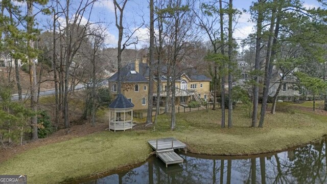 back of house with a wooden deck, a lawn, and french doors