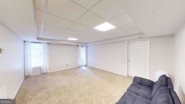 interior space with a drop ceiling and light colored carpet