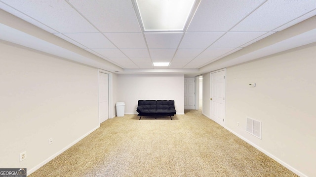 unfurnished room featuring a paneled ceiling and light colored carpet