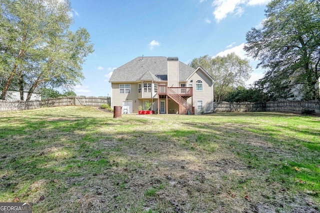 back of house with a wooden deck and a lawn