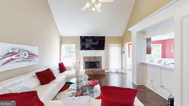 living room featuring a brick fireplace, vaulted ceiling, dark hardwood / wood-style floors, and a healthy amount of sunlight