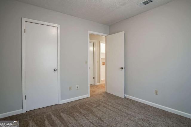 unfurnished bedroom featuring carpet floors and a textured ceiling