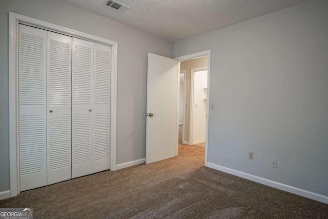 unfurnished bedroom with a closet, a textured ceiling, and carpet flooring