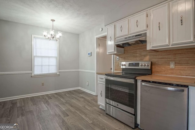 kitchen with white cabinetry, a textured ceiling, light hardwood / wood-style flooring, pendant lighting, and stainless steel appliances