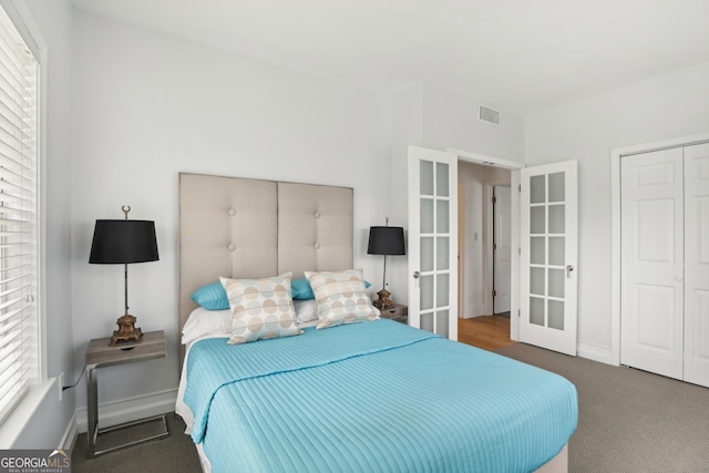 carpeted bedroom featuring a closet and french doors