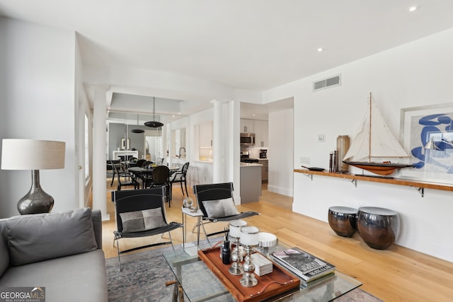 living room featuring hardwood / wood-style flooring and decorative columns