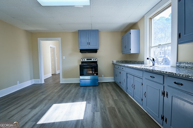 kitchen featuring stainless steel electric range oven, dark hardwood / wood-style floors, light stone countertops, and sink