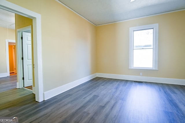 spare room featuring dark hardwood / wood-style flooring and crown molding