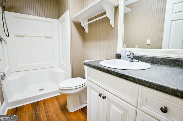 bathroom with vanity, a shower, hardwood / wood-style floors, and toilet