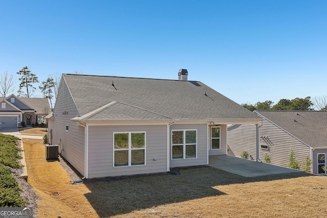 back of house featuring a lawn, central AC, and a patio area