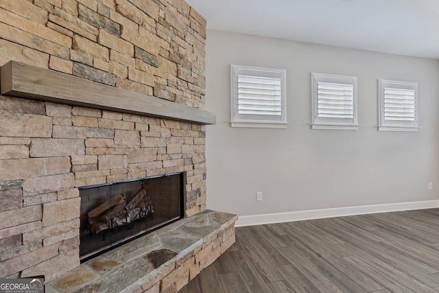 unfurnished living room featuring dark wood-type flooring and a fireplace