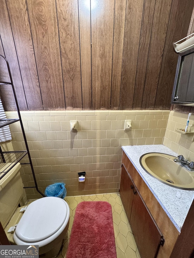 bathroom featuring tile walls, vanity, and toilet