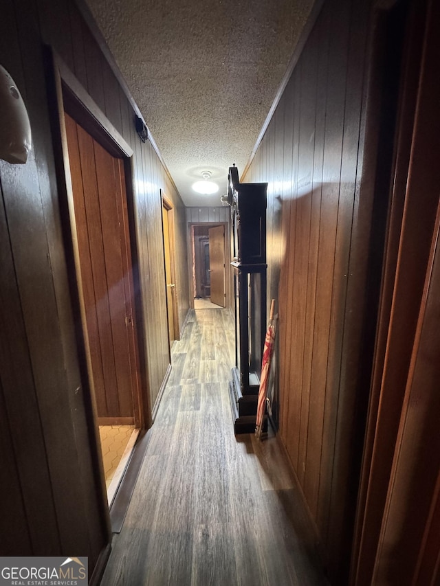 corridor with crown molding, hardwood / wood-style flooring, and a textured ceiling