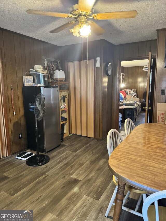 dining space with ceiling fan, dark hardwood / wood-style floors, and a textured ceiling