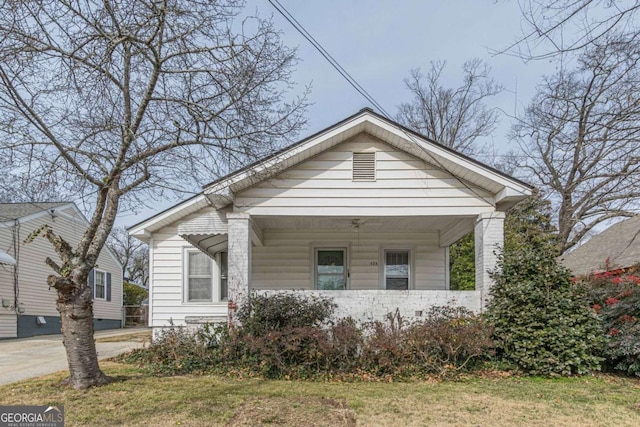 bungalow-style house featuring a porch and a front lawn