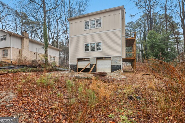 rear view of property with a garage and board and batten siding