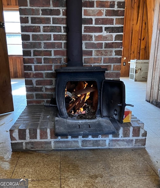 interior details with wooden walls and a wood stove