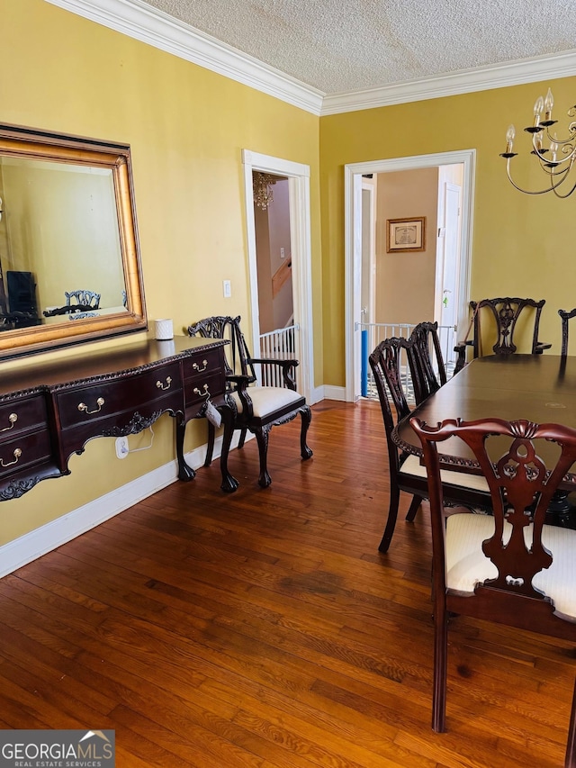 dining area with hardwood / wood-style flooring, ornamental molding, and a textured ceiling