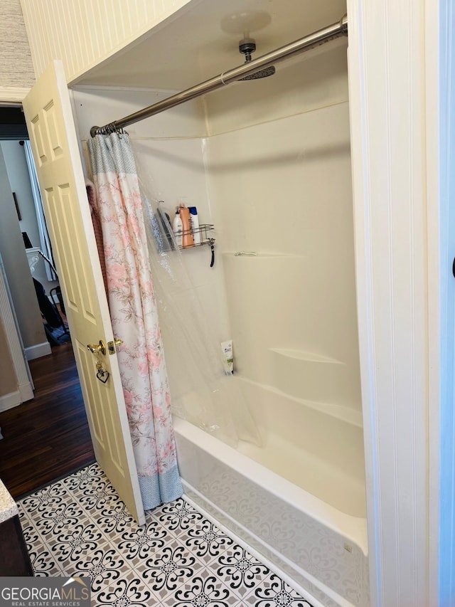 bathroom with shower / tub combo with curtain and tile patterned floors