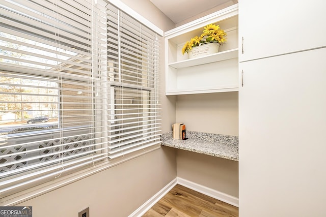 interior space with built in desk and light hardwood / wood-style flooring