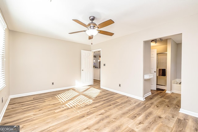 unfurnished bedroom with connected bathroom, ceiling fan, and light hardwood / wood-style flooring