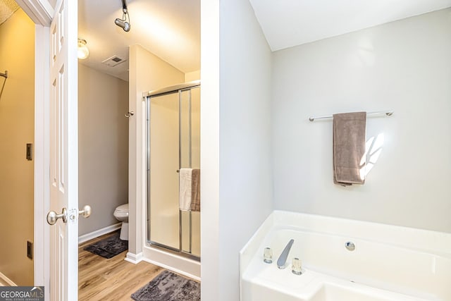 bathroom with wood-type flooring, plus walk in shower, and toilet