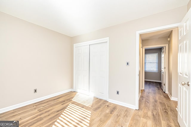 unfurnished bedroom with light hardwood / wood-style floors and a closet