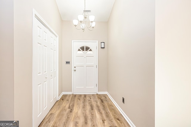 entryway with an inviting chandelier and light hardwood / wood-style floors