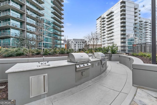 view of patio with exterior kitchen, a grill, and sink